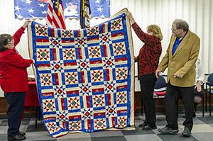 people holding quilt