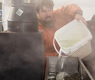 Chaning Richardson at Forgotten Foods Farm in Olive Hill fills the evaporator with maple sap and oversees the process. Photo by Stephen Patton Chaning Richardson at Forgotten Foods Farm in Olive Hill fills the evaporator with maple sap and oversees the process. Photo by Stephen Patton