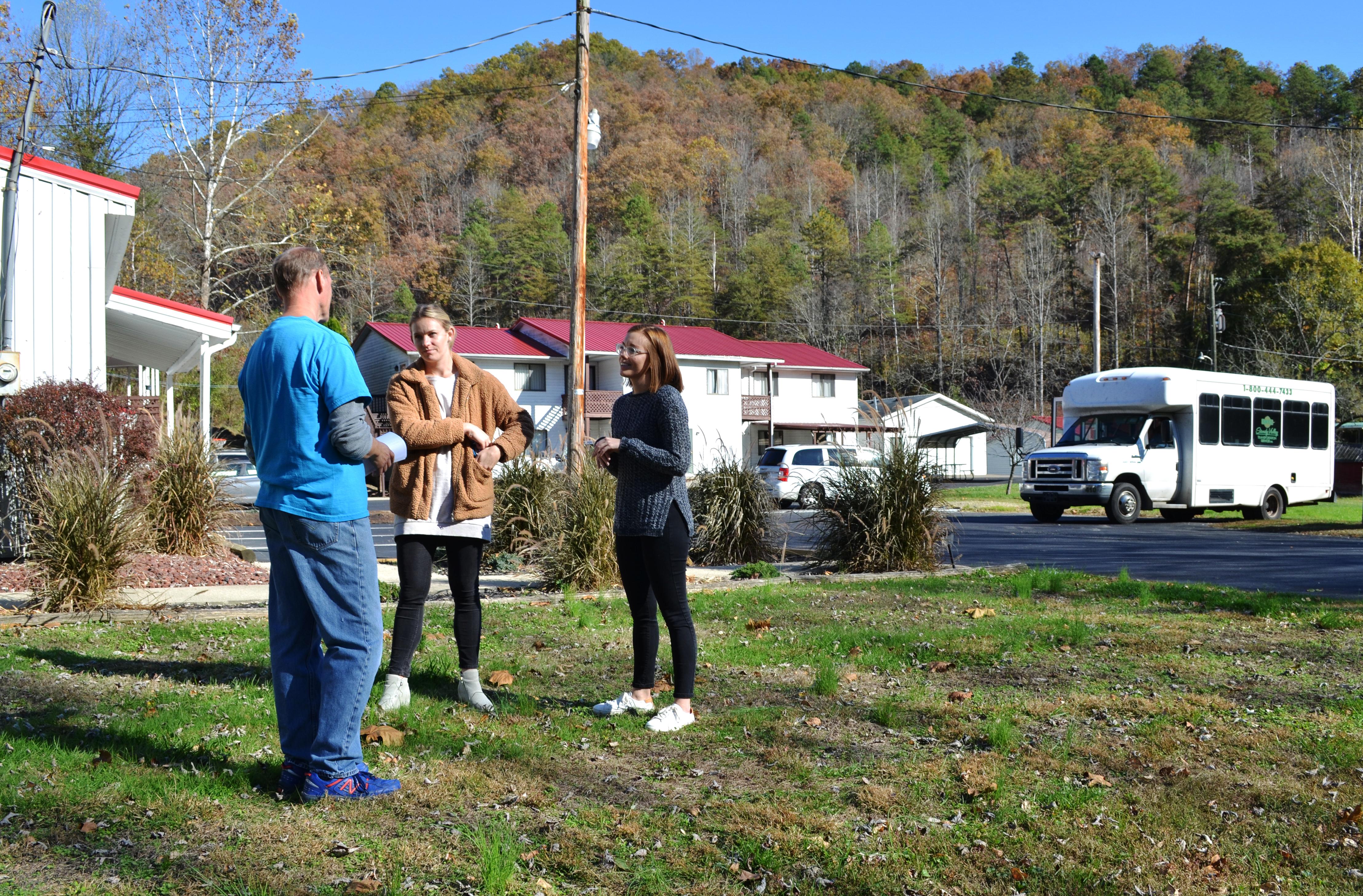 Rachel Gillespie, left, and Emily DeWitt, UK extension associates, talk with Bill Zuidema outside of Appalachian Reach Out in Martin County.  Photo by Katie Pratt, UK agricultural communications.