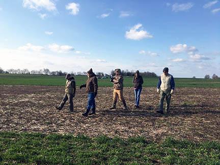 Researchers walk across one of Richard Preston's fields. Researchers walk across one of Richard Preston's fields.