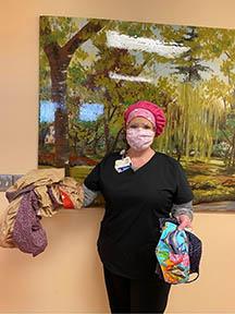 Health care worker displays caps and masks made by Taylor County Extension Homemakers. Photo provided by Taylor Regional Hospital