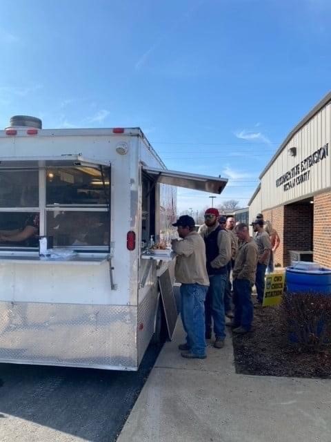 Linemen gather for food outside of the Hickman County Extension office. Local emergency management secured the food truck while extension provided dessert, the space and UK goodies. Photo by Melissa Goodman, Hickman County FCS agent.