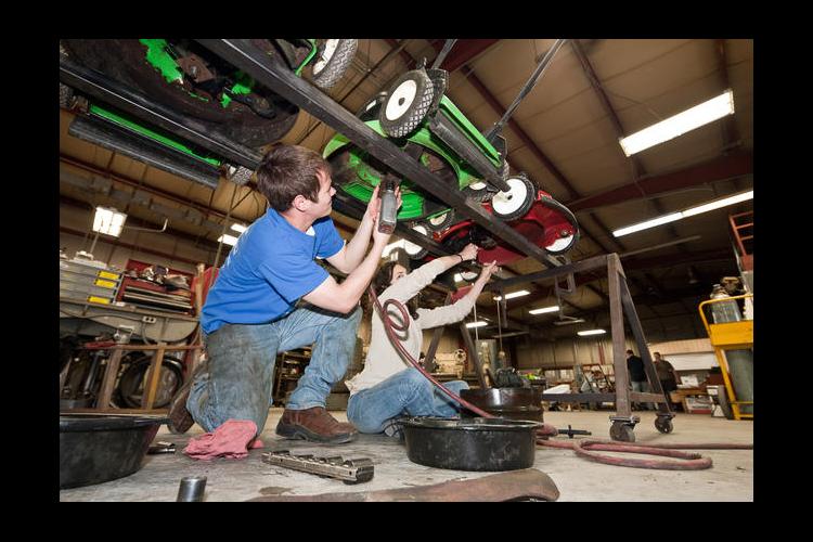 BAE students working on lawnmowers in a previous clinic. 