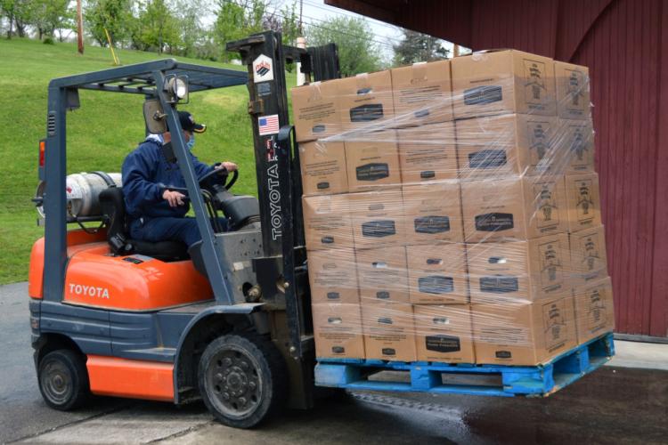Forklift carrying a pallet of food boxes