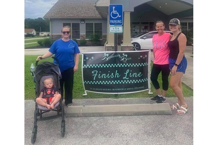 Tinley Creech, Darian Creech, Connie Campbell and Ashton Burks pose by the finish line after completing the virtual 5K as part of the Wolfe County Addiction Recovery Week.  All are members of the same household. Photo provided. 