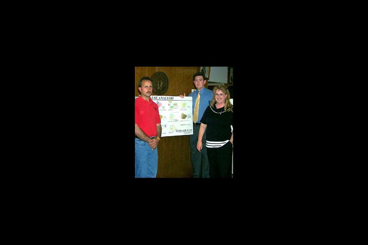 The 2000 Heritage Plan suggests land use guidelines using state-of-the-art graphics. Pictured are community leader Charles Ray Pennington (left), UK student Jeff Townsend (center), and Elliott County Extension Agent Gwenda Adkins.