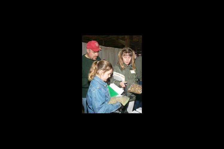 The Kramer family of Own County examines different types of goat rations at the recent Goat Day at Kentucky State University's Research Farm.