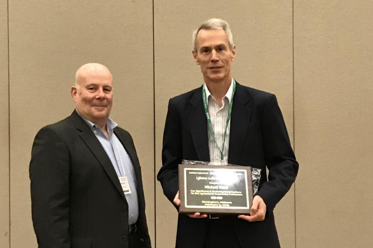 UK's Michael Reed, right, receives an Lifetime Achievement Award from Jeff Jordan, left, treasurer of the Southern Agricultural Economics Association. Photo by Barry Barnett, UK professor and chair of the Department of Agricultural Economics.