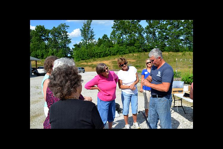 Ted Johnson, Lee County extension agent, shows participants at his raised bed gardening workshop how to install irrigation. 