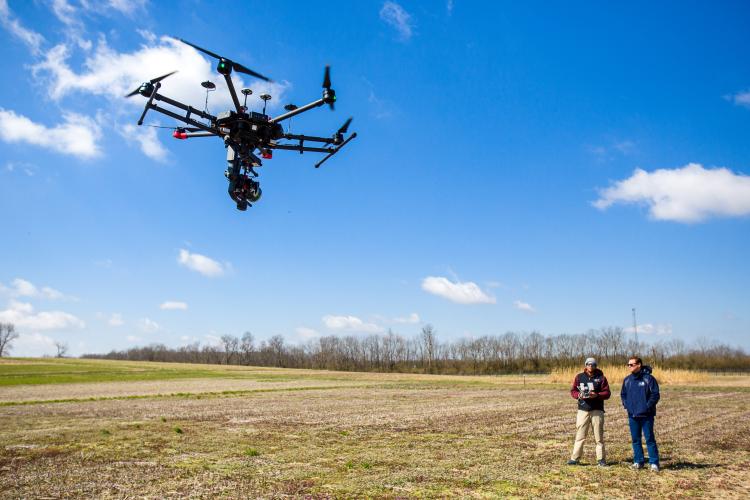 Joshua Jackson, UK assistant professor, and Shawn O'Neal, UK graduate student fly a drone at one of UK's farms. Photo by Matt Barton, UK agricultural communications.