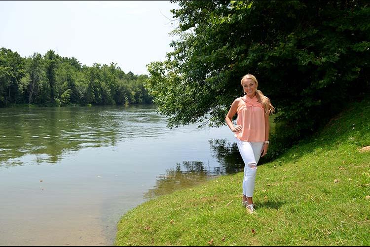 Molly Morgan stands next to the Cumberland River. 