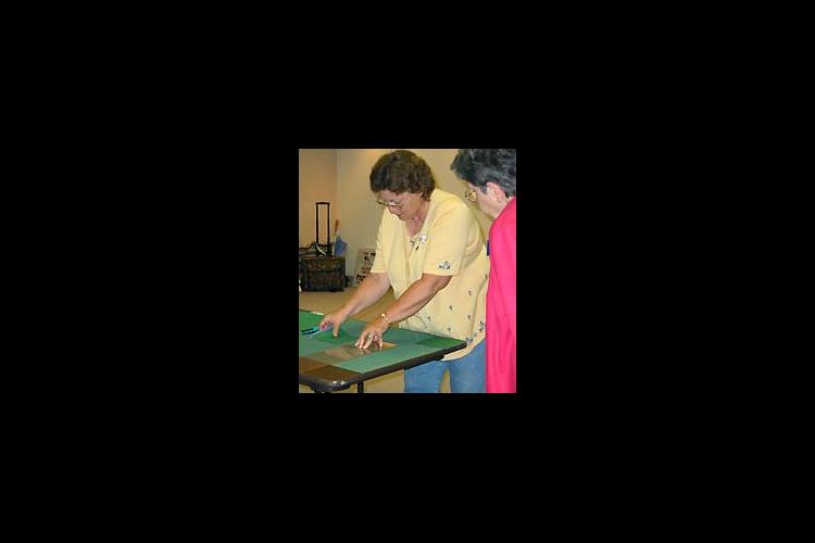 Claudine Williamson, president of Greenup County Homemakers, learns basic quilting skills.