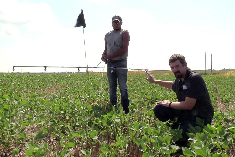 UK weed scientist Travis Legleiter, foreground, explains how boom height affects herbicide drift. Shawn Wood, UK senior lab technician, holds the spray boom. Photo provided.