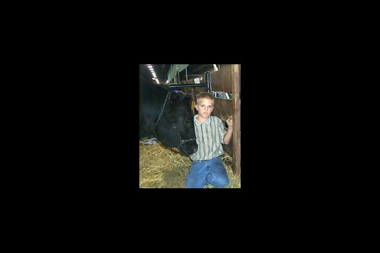 Tyler Halley stands by his prize winning steer. 