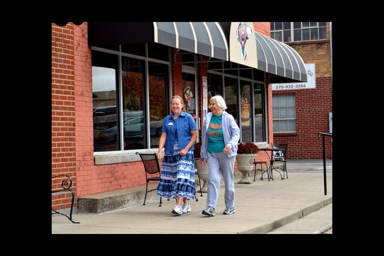 Missy Curry, left, and Suzanne Taylor walk on Greensburg's Merchant Mile.