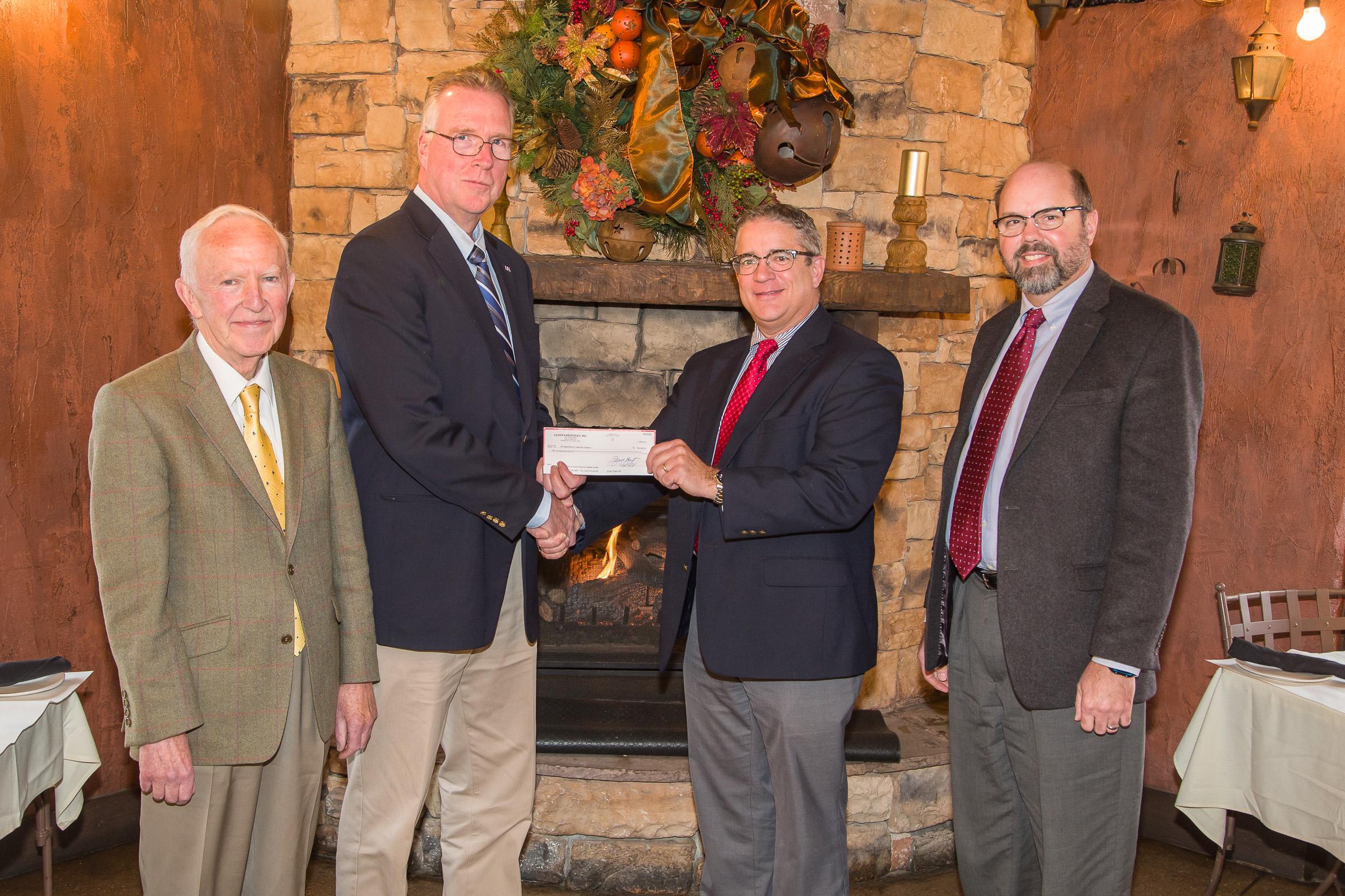 Pat Talley (Center Right), Regional Director, U.S. Central Lloyd's America,  gives Dr. David Horohov (Center Left), Chair, Department of Veterinary Science,  a check on behalf of Underwriters at Lloyd's, London to support publication of the Equine Disease