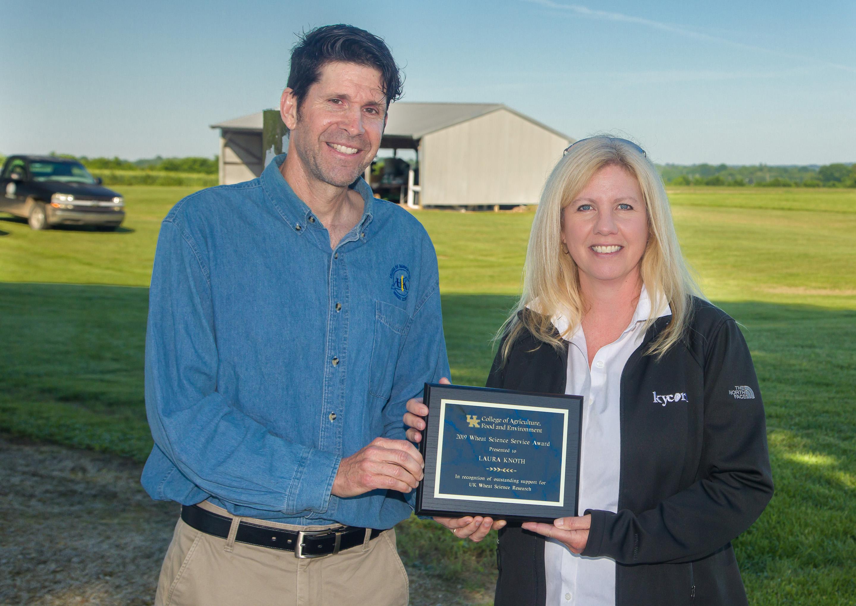 Bill Bruening of the UK Wheat Science Group presents Laura Knoth with the group's Service Award during the UK Wheat Field Day. Photo by Steve Patton, UK agricultural communications.