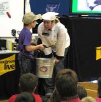 woman talking to child holding bucket