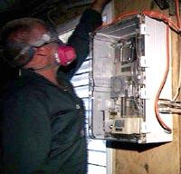 A gas sampling box is mounted near a ventilation fan. 