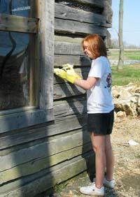 student cleaning cabin exterior