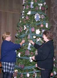 Greenup Co. Homemaker's President Alice Baker decorates the main tree with current decorating chairwoman Claudine Williamson.