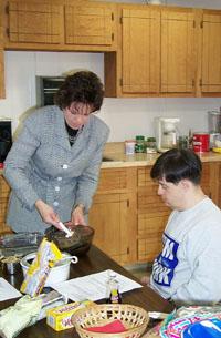 Jill Harris, Todd County Extension Agent for Family and Consumer Sciences, shows class members how to stir a bowl of fudge.