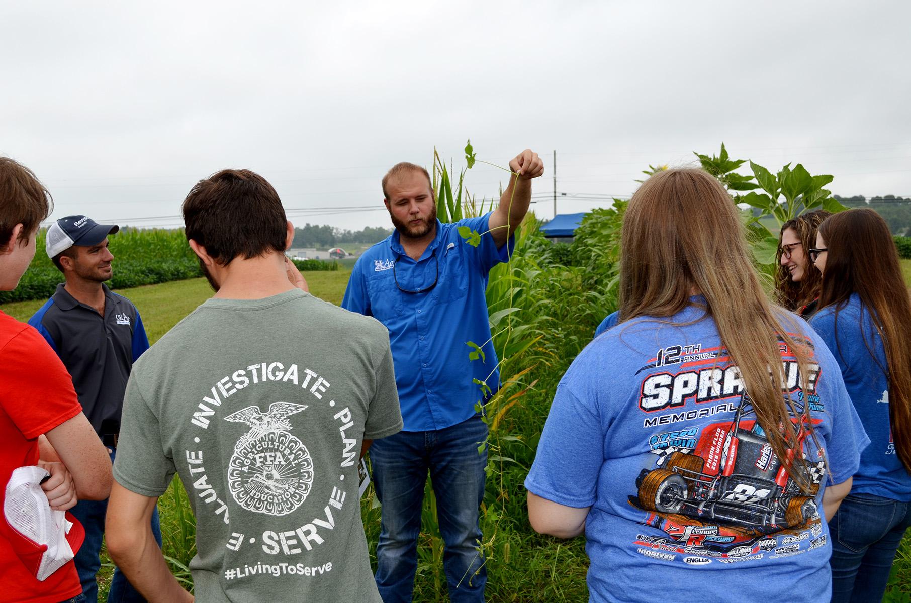 Zach Perry, UK graduate student, explains the defining characteristics of an ivyleaf morningglory. Photo by Katie Pratt, UK agricultural communications.