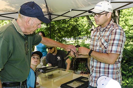 UK Forestry's Steven Price (r) shows off a snake at the Robinson Forest Field Day. 