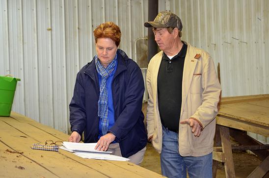 Carol Hinton, left, and tobacco grower Eddie Dyer review Dyer's farm records. 