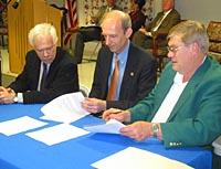 Robert Shay, Larry Turner and Larry Dotson sign a memorandum of understanding to work together in promoting fine arts in Kentucky.