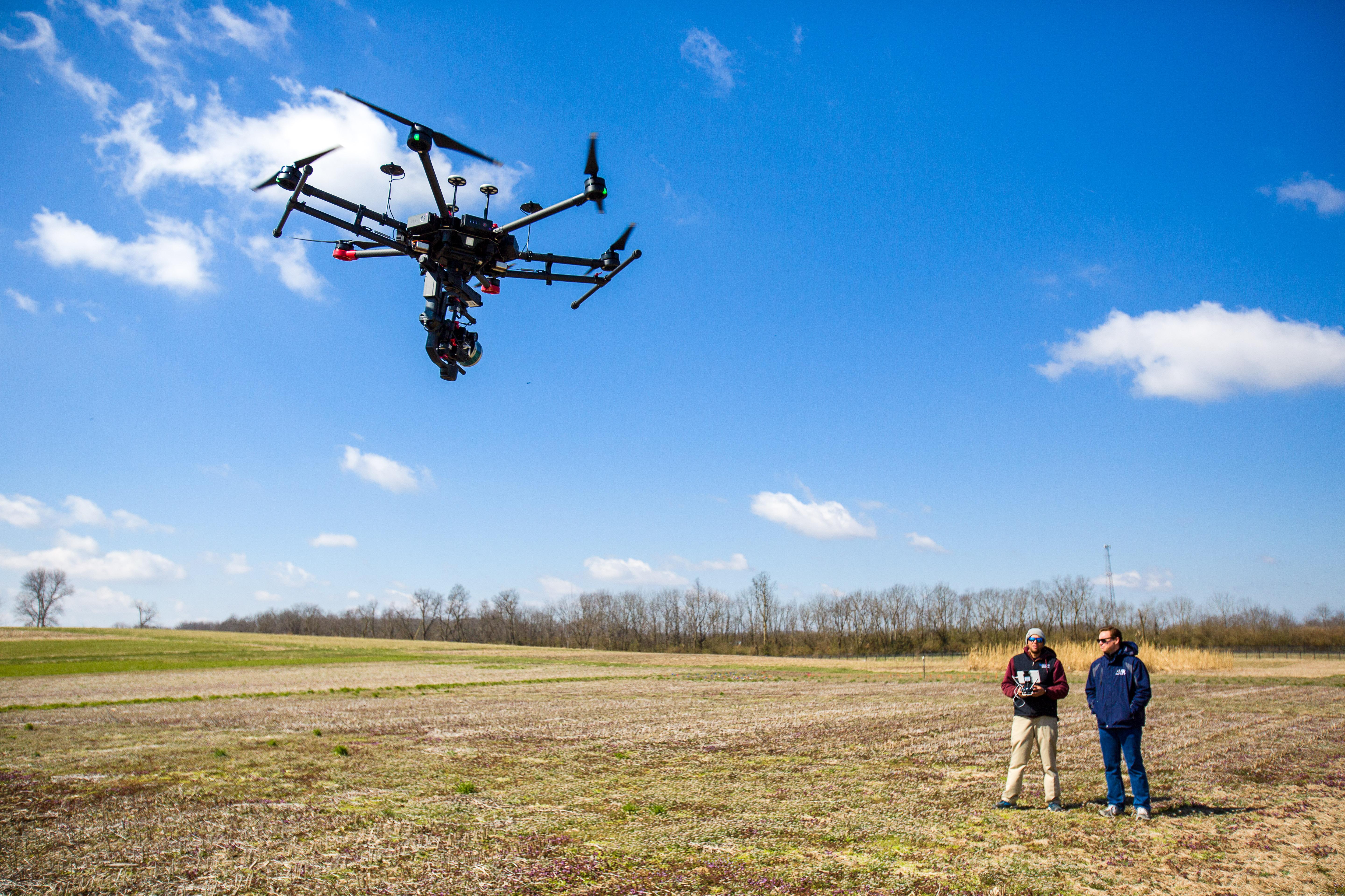 Joshua Jackson, UK assistant professor, and Shawn O'Neal, UK graduate student fly a drone at one of UK's farms. Photo by Matt Barton, UK agricultural communications.