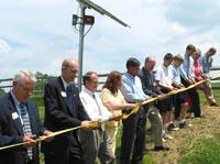 Officials cut a ribbon to signify the beginning of solar power at the Environmental Education Center.