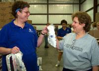 UK employees Jean Smith (left) and Judy McCracken help fill food baskets at God's Pantry.