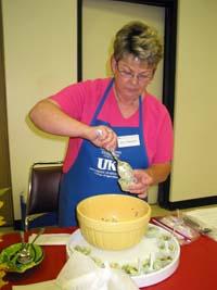 Sue Parrent, Crittenden County EFNEP assistant, prepares samples of broccoli salad supreme for visitors to the Kentucky Garden Basket Taste Testing at the Princeton Research and Education Center’s Field Day July 28.