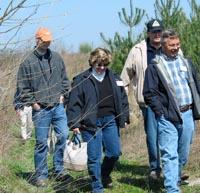 Tour participants walk through trees planted on uncompacted soil.