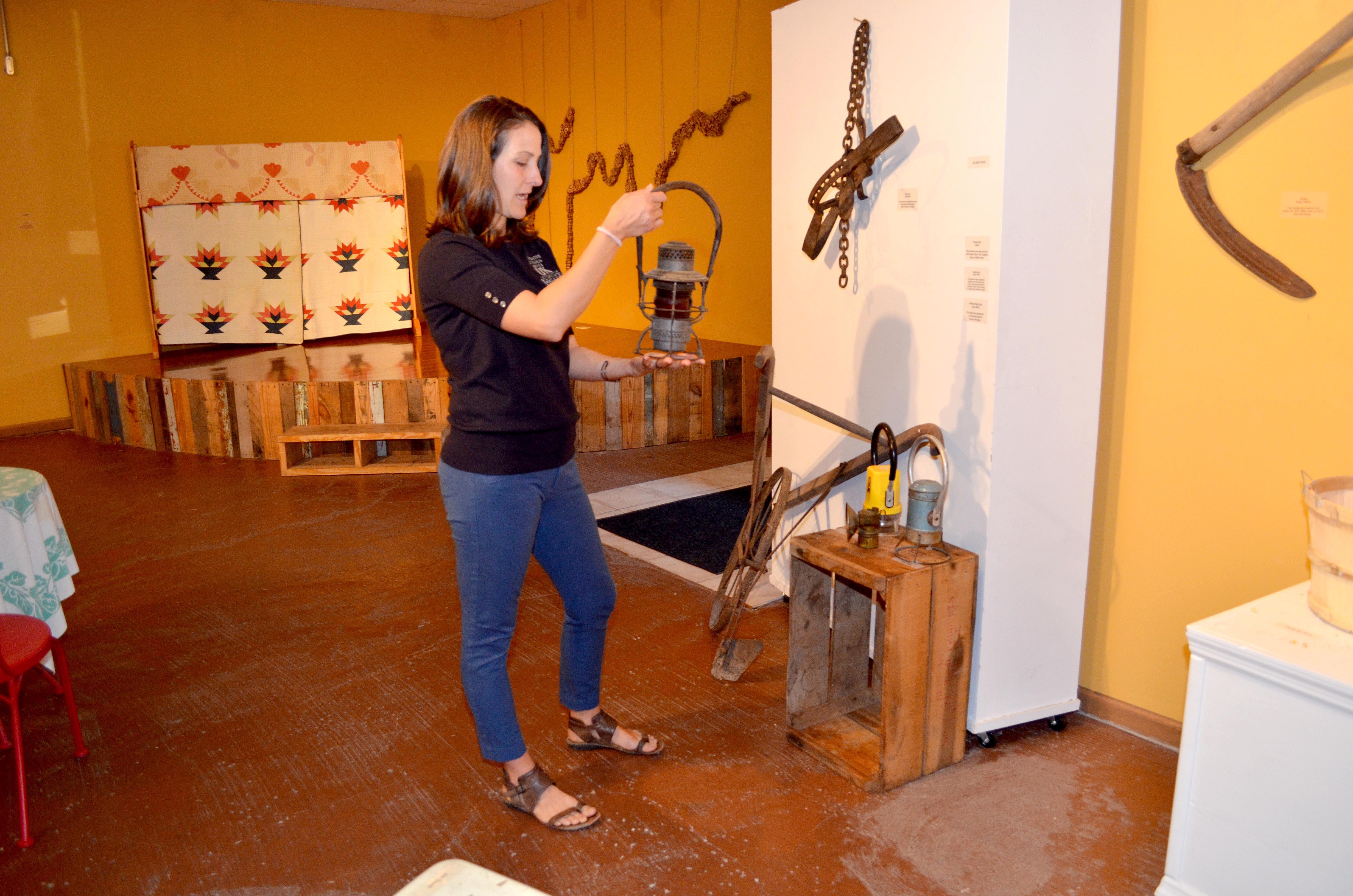 Cortney Moses shows on railroad lanterns that are on display in the ARTifacts exhibit. 
