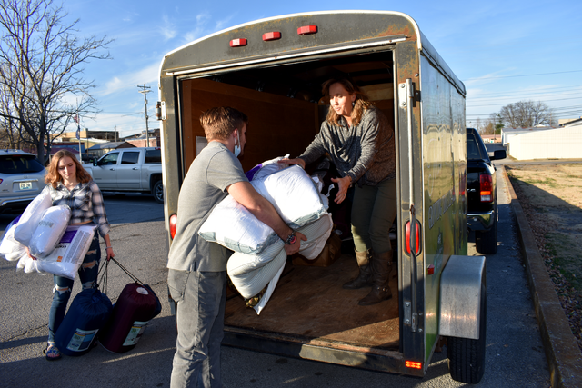 Todd County 4-H'er Andrew McDonald hands bedding supplies to Lee Ann McCuiston, Todd County 4-H youth development agent, who was loading a trailer of supplies to take the West Kentucky 4-H Camp in  Dawson Springs. 