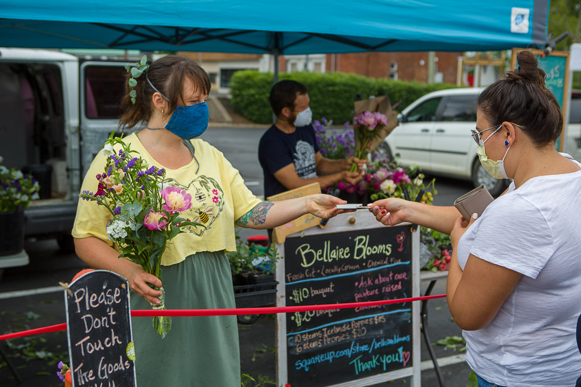 Shelby Wheeler of Bellaire Blooms helped a customer with flowers at the Lexington Farmers Market. Photo by Matt Barton