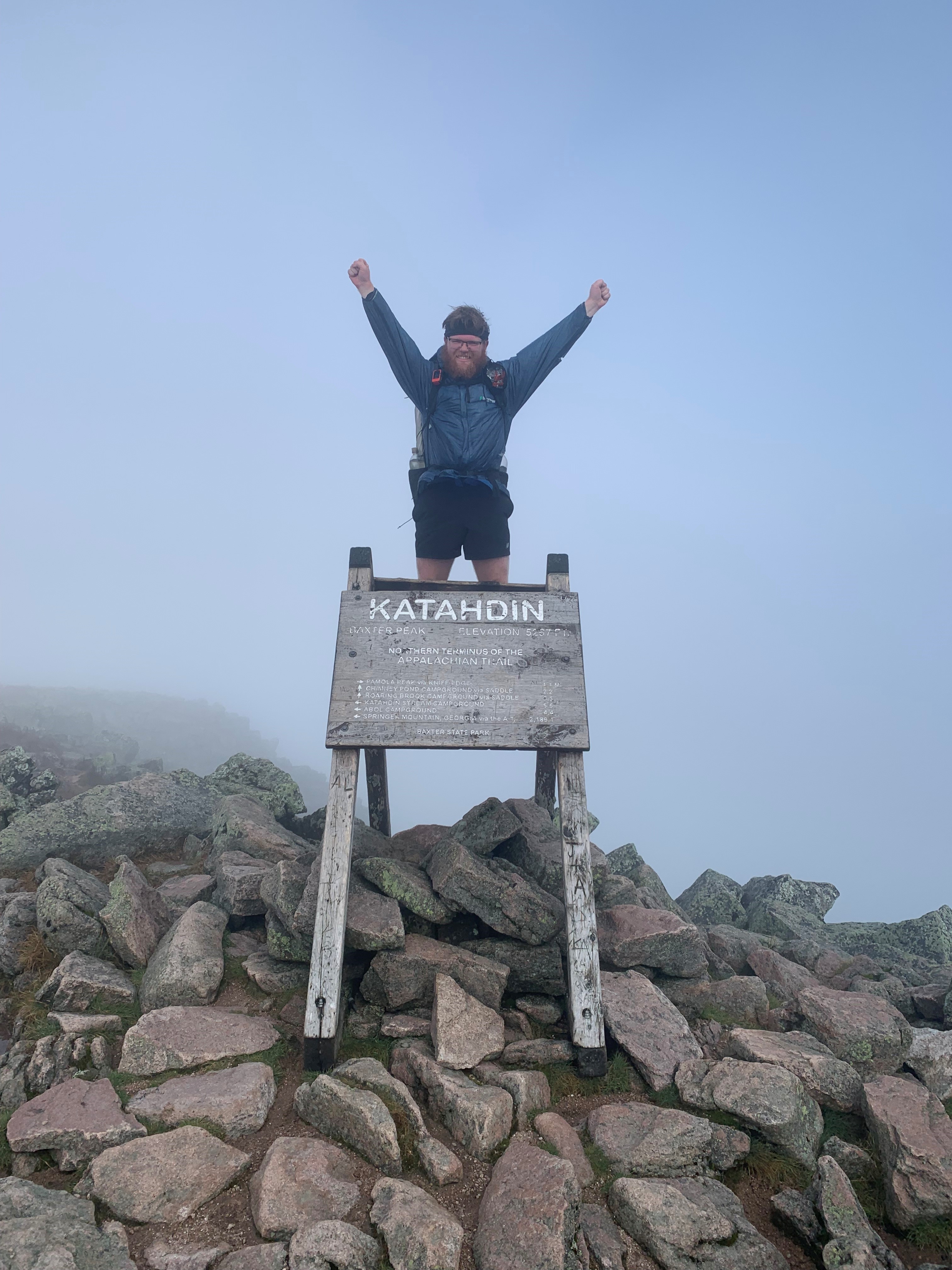 Clay Comer with arms raised, showing excitement in completing the Appalachian Trail