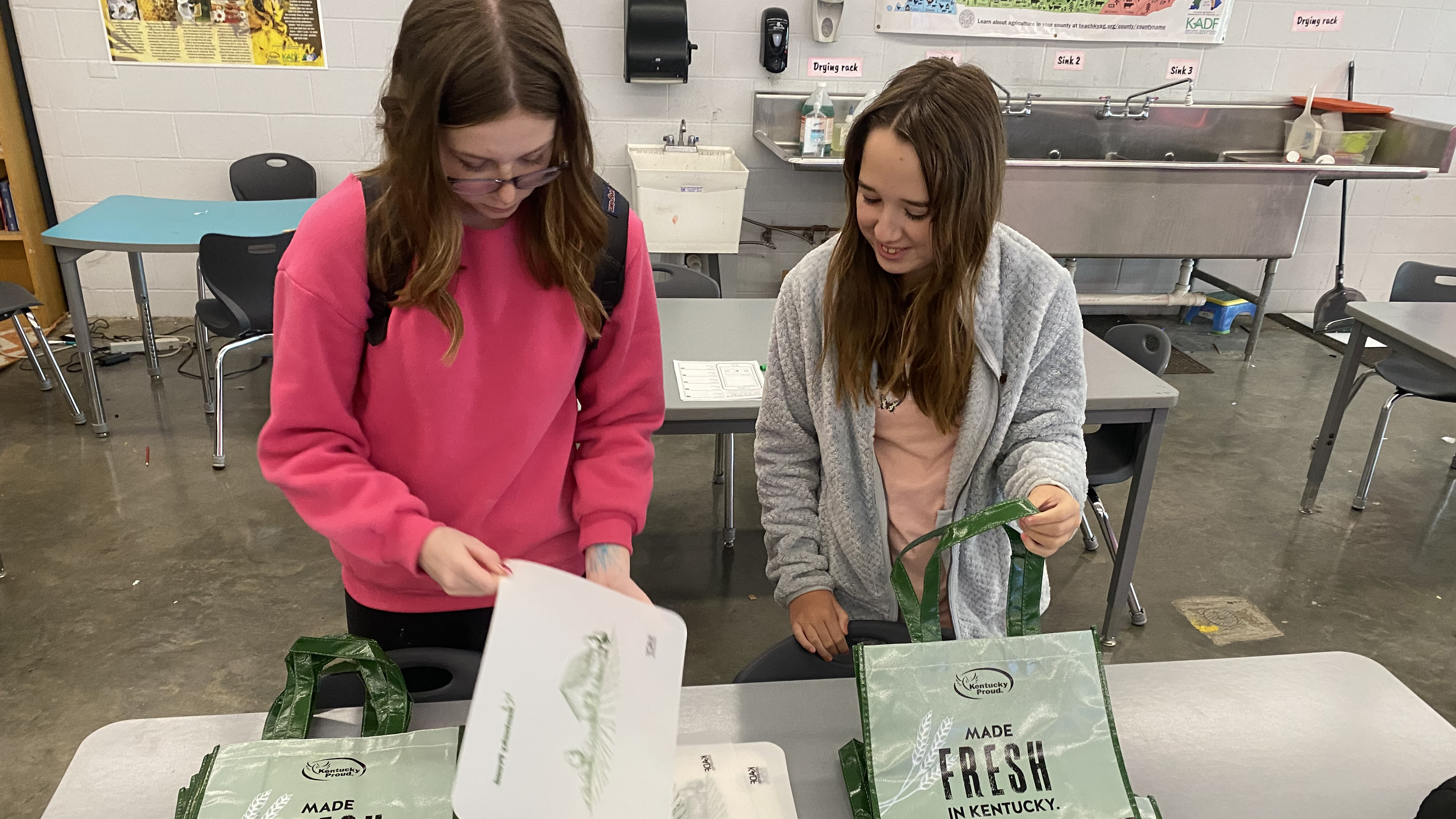 Two students putting together food boxes