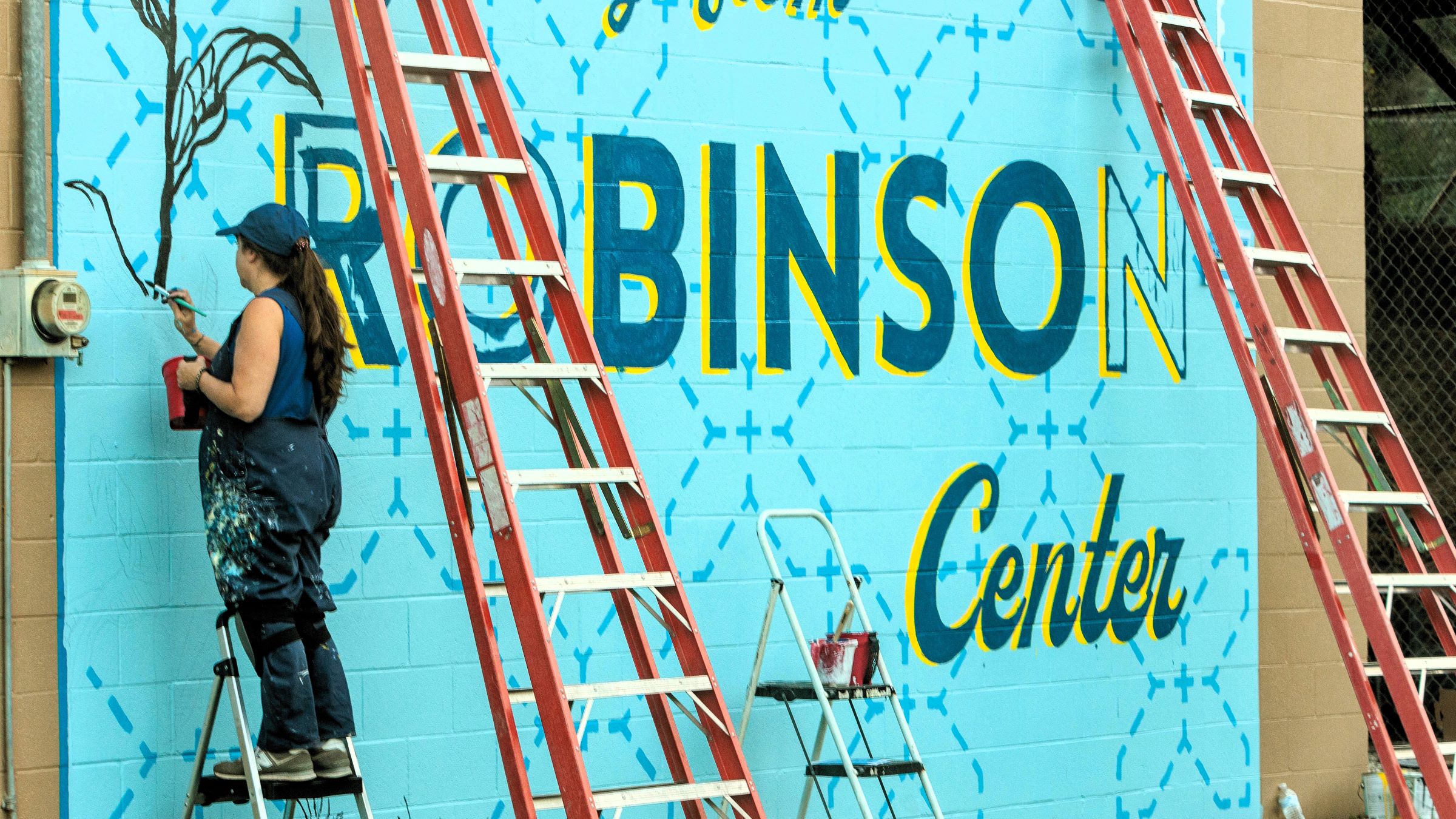 Field Day participants adding paint to a mural to help celebrate the Robinson Center's history and culture. Photo by Matt Barton.