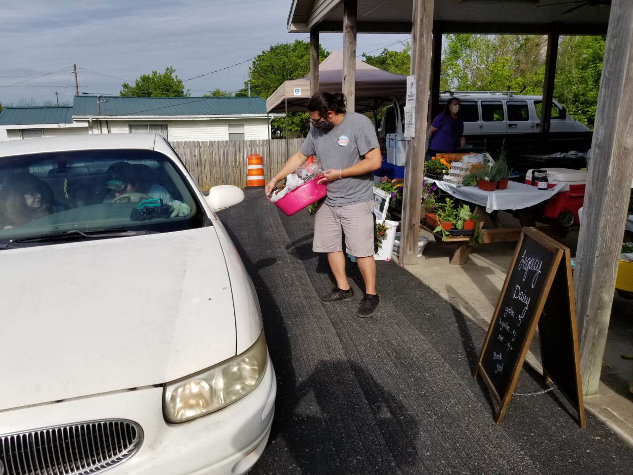 Safety first at the Metcalfe Count Farmers Market. A vendor brings his products to a drive-thru customer. Photo by Lynn Blankenship