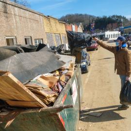 Benjamin Bayless, AGR member and a junior agricultural ecosystems sciences major from Franklin, throws trash into a dumpster in downtown Beattyville. Photo by Matt Barton, UK agricultural communications.