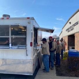 Linemen gather for food outside of the Hickman County Extension office. Local emergency management secured the food truck while extension provided dessert, the space and UK goodies.  Photo by Melissa Goodman, Hickman County FCS agent.