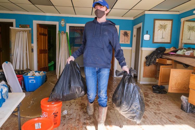 Ty Cheatham, AGR Fraternity member and a freshman agricultural and medical biotechnology major from Adair County, removes trash from a building in downtown Beattyville on March 5. Photo by Matt Barton, UK agricultural communications.