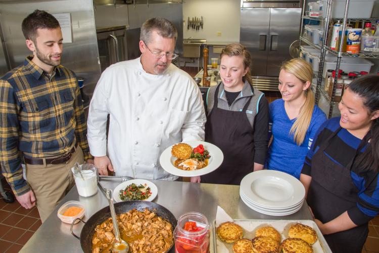 UK chef Bob Perry plates a meal with students.
