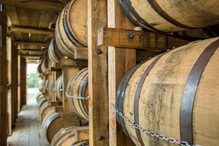 Bourbon barrels sitting in a rickhouse.