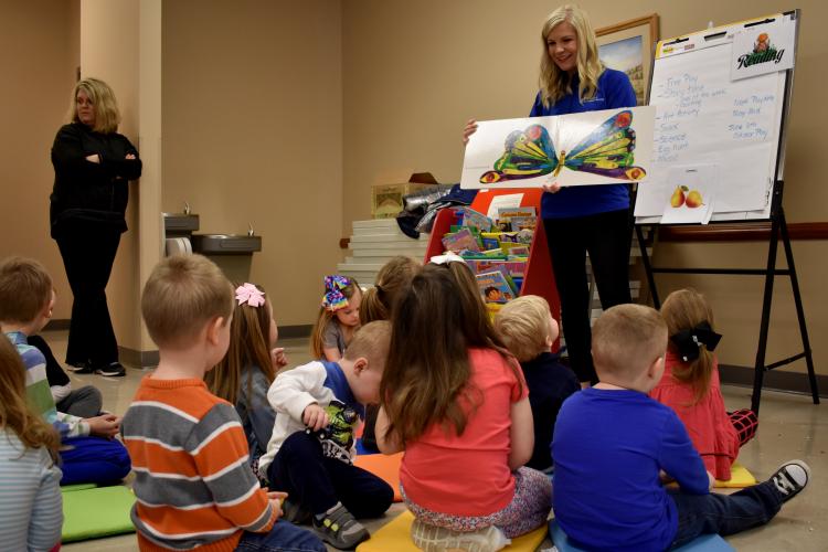 Whitney Morrow reads to young children attending her Play Date program. 