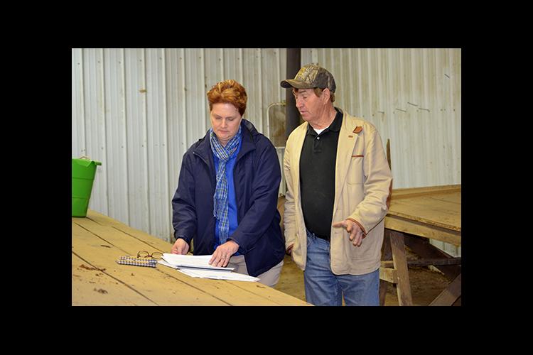 Carol Hinton, left, and tobacco grower Eddie Dyer review Dyer's farm records. 
