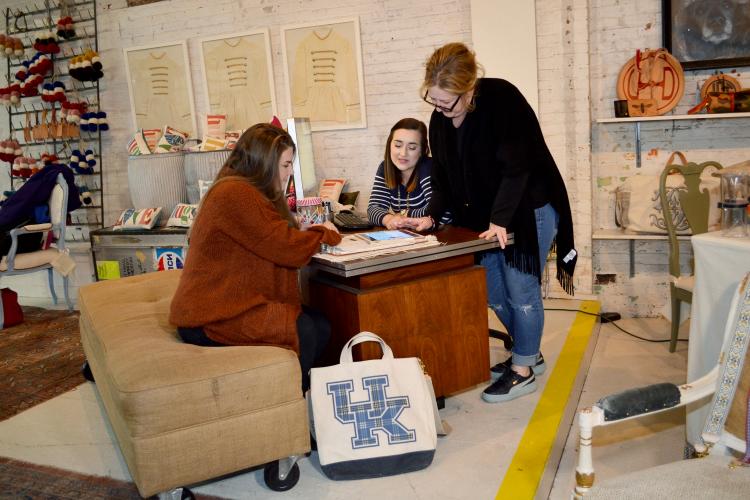 UK students Megan Stevenson, left, and Emily Stugan, center, look at Henry Dry Goods social media analytics with company owner Sherri Henry Wolf. Photo by Katie Pratt, UK agricultural communications.